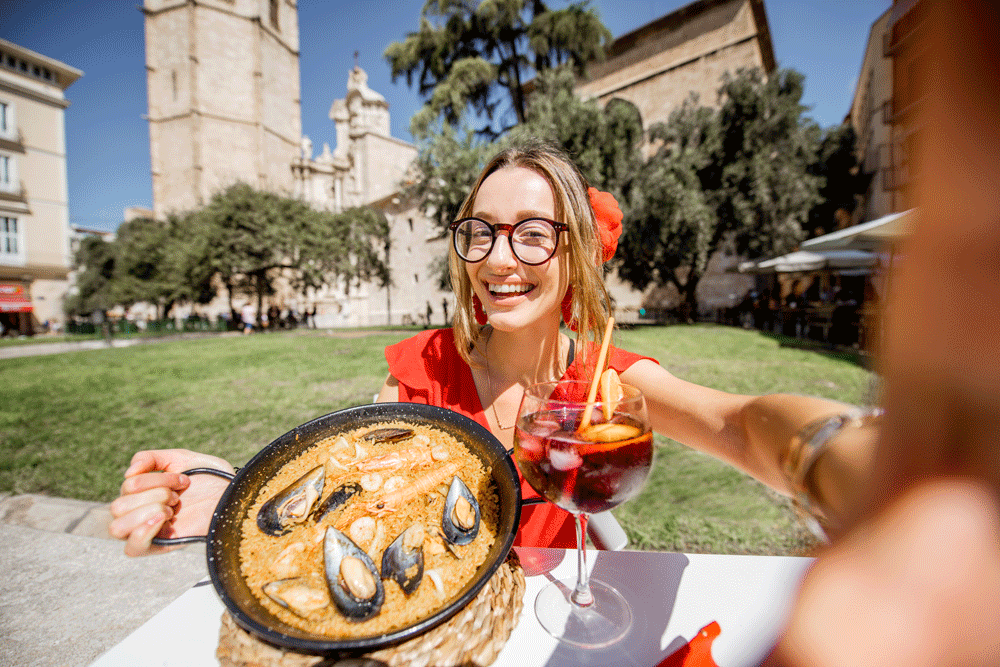 Young woman eating paella in Valencia